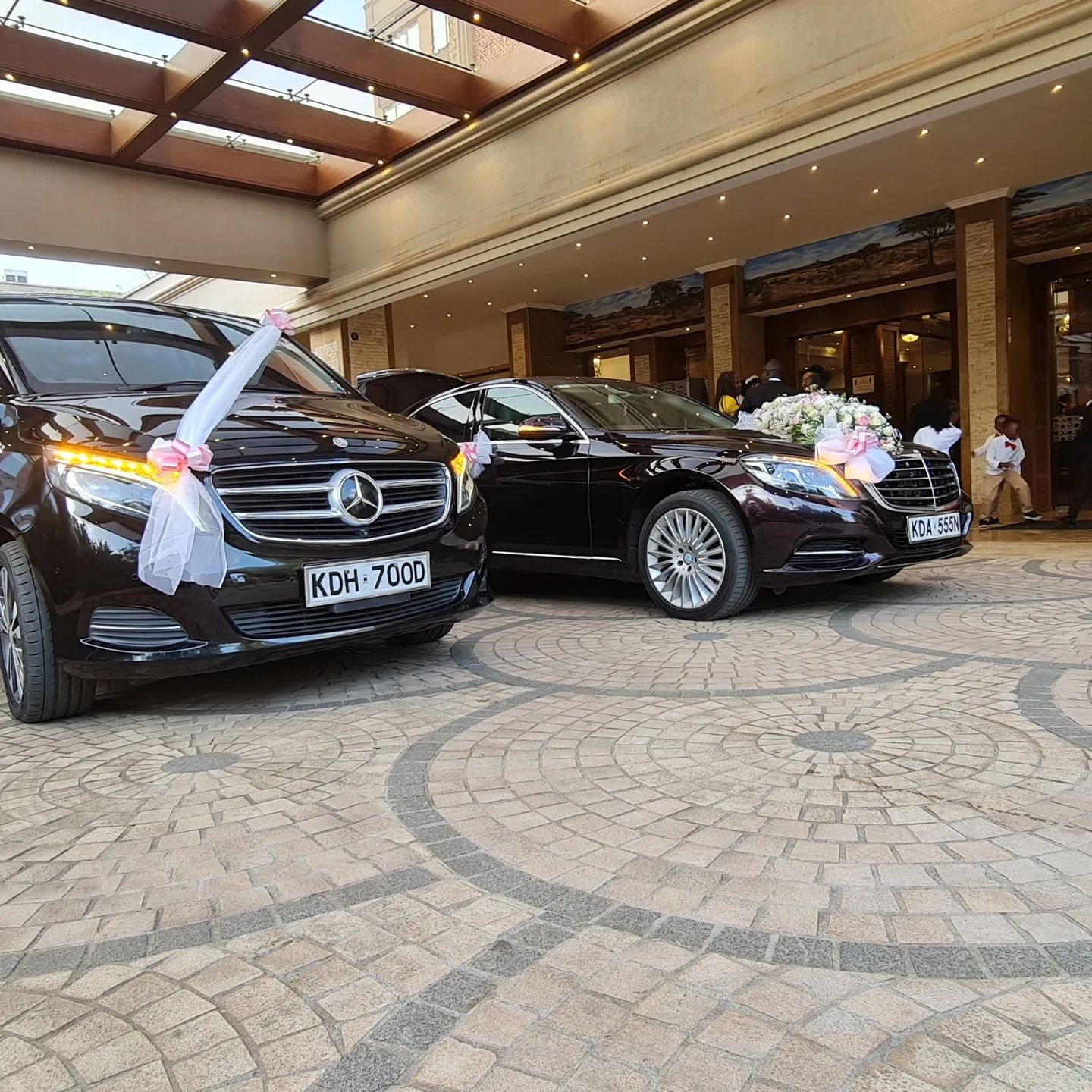 Ribboned Mercedes-Benz V-Class and E-Class wedding motorcade supplied by Supreme Concierge at a Nairobi hotel